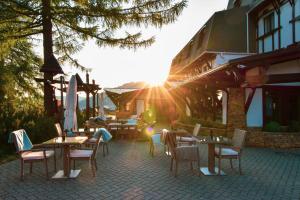 a patio with tables and chairs in front of a building at Šport Hotel *** Donovaly in Donovaly