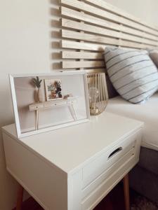 biały stół z obrazem na łóżku w obiekcie Cozy Trg w mieście Lazarevac