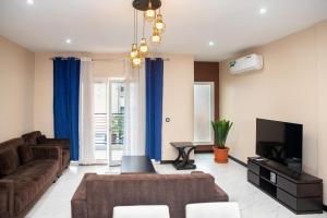 a living room with a couch and a tv at Bel appartement chambre Omnisport in Yaoundé