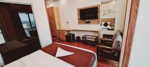 Hotel Freedom Star ReTreat في مومباي: غرفة في الفندق مع سرير ومكتب