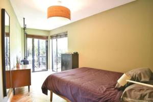 a bedroom with a bed and a large window at Modern 2 bed flat with gardens in London