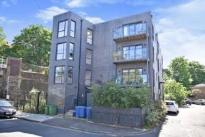 a large gray building on a street at Modern 2 bed flat with gardens in London