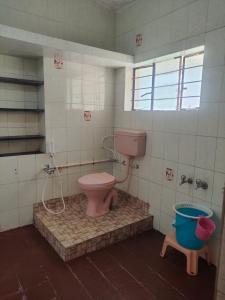 bagno con servizi igienici rosa e secchio di TRIOS a Ooty