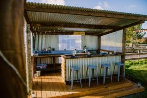 un bar en una cubierta con taburetes alrededor en Rosgarron Safari Canvas Lodge Glorious Glamping en Magherafelt