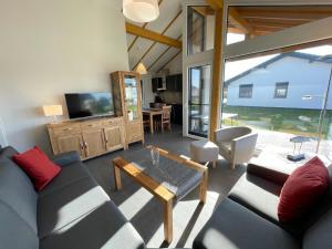 a living room with a couch and a tv at G11 Eingezäuntes Neubau-Haus in Eckwarderhörne in Großwürden
