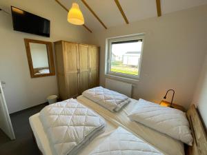 a bedroom with two beds and a window at G11 Eingezäuntes Neubau-Haus in Eckwarderhörne in Großwürden