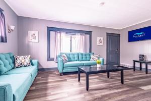 Sala de estar con sofás azules y mesa de centro en Spacious 6BR 2Bath Close the Falls, en Niagara Falls