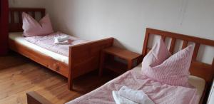1 dormitorio con 2 camas y almohadas rosas en Große Ferienwohnung in Bugewitz mit Gepflegtem Garten, en Bugewitz