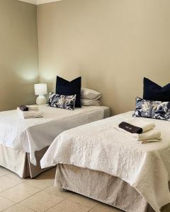 dwa łóżka siedzące obok siebie w pokoju w obiekcie Waterlily Cove Guesthouse w mieście Pretoria