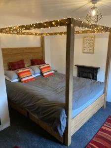 a bedroom with a canopy bed with lights on it at Leven's Rest - 2 Bed Maisonette in Backbarrow