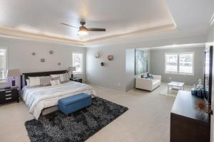 1 dormitorio con 1 cama y ventilador de techo en Beautiful relaxing private villa next to a pond smart home and Traeger Grill, en Overland Park