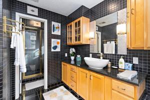 a black tiled bathroom with a sink and a shower at Hillside vacation next to Overland Park Kansas nature trail grill and fun in Stilwell +61 photos