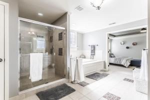 y baño blanco con ducha y bañera. en Beautiful relaxing private villa next to a pond smart home and Traeger Grill, en Overland Park