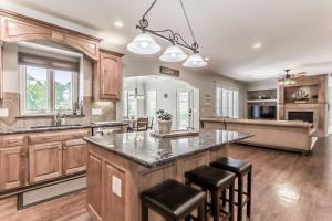 a large kitchen with a large island with bar stools at Beautiful relaxing private villa next to a pond smart home and Traeger Grill in Overland Park
