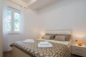 a bedroom with a bed with two towels on it at Villa La Plazza in Dugopolje +44 photos