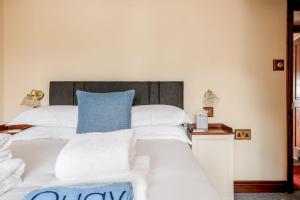 Una cama blanca grande con una almohada azul. en The Old Townhouse - Room 3, en Poole