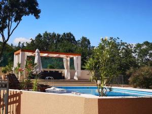 a swimming pool with a gazebo next to a swimming pool at Villa La Plazza in Dugopolje