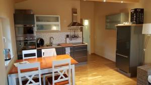eine Küche mit einem Holztisch und eine Küche mit Küchengeräten aus Edelstahl in der Unterkunft Villa Albatros in Ober-Dellach