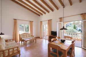 a large living room with a table and chairs at Villa Diana in Cala'n Porter