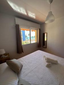 Un dormitorio con una gran cama blanca con ventana. en Nonna Beach Apartment Two-Bedroom, en Rincón de la Victoria