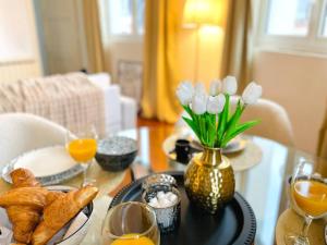 un tavolo con un vaso di tulipani bianchi sopra di La Suite COCO, Chic & Hypercentre a Beauvais