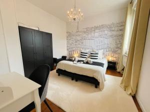 una camera da letto con un letto grande e un lampadario di La Suite COCO, Chic & Hypercentre a Beauvais