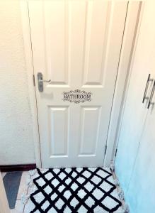 a white door with a black and white checkered floor at Cozy single room in city center in Newry