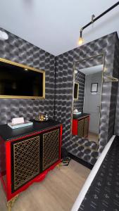 y baño con espejo grande y tocador rojo. en Hotel Helene, en Medellín