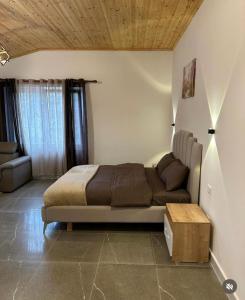1 dormitorio con 1 cama y 1 sofá en Qyteza Guest House & Camping en Shkodër