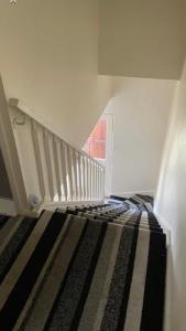 a room with a staircase with a bed and a rug at Cozy single room in city center in Newry