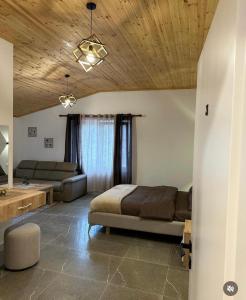 a bedroom with a bed and a couch in a room at Qyteza Guest House & Camping in Shkodër +41 photos