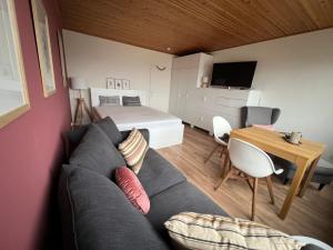 a room with a couch and a bed and a table at Burgtiefe Südstrand "Haven Stuuv" in Fehmarn