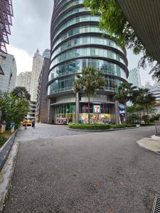 un gran edificio de cristal en medio de una calle en Vortex suites klcc by Rahat, en Kuala Lumpur