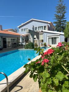 une maison avec une piscine et quelques fleurs dans l'établissement MAR VERDE - Parede-Cascais, à Parede