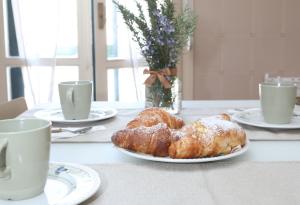 a table with two croissants and two cups of coffee at Casa in centro Ragusa con parcheggio privato in Ragusa