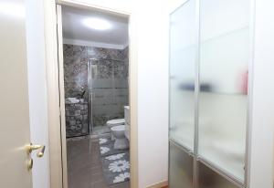 a bathroom with a toilet and a walk in shower at Casa in centro Ragusa con parcheggio privato in Ragusa