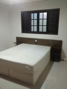 ein großes Bett in einem Zimmer mit Fenster in der Unterkunft Chacara Toca do urso in Santa Isabel