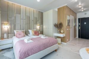 a bedroom with a pink bed and a bathroom at Ferienwohnung am Meer, Urlaub auf der Insel Usedom, Apartment Lividus 135 in Świnoujście