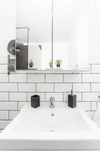 a white bathroom with a sink and a mirror at Apartamento Daniella in Puerto Naos