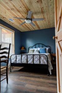 Schlafzimmer mit einem Bett und einem Deckenventilator in der Unterkunft Hideaway Cabin near Mammoth Springs, Ark in Mammoth Spring