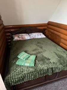 een bed met een groen dekbed en twee zakken erop bij Добрий Хутор in Sukhyy Lyman