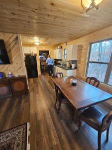 ein Esszimmer mit einem Holztisch in einer Hütte in der Unterkunft Hideaway Cabin near Mammoth Springs, Ark in Mammoth Spring