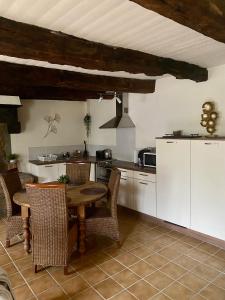 a kitchen with a table and chairs in a room at Le Ginkgo in Caulnes