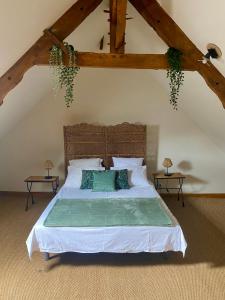 a bedroom with a large bed in a attic at Le Ginkgo in Caulnes
