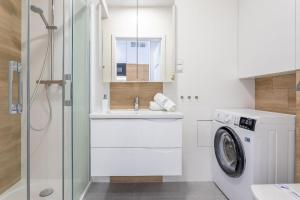 een badkamer met een wasmachine en een wastafel bij Ferienwohnung am Meer, Urlaub auf der Insel Usedom, Apartment Albus 409 in Świnoujście