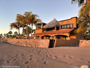 a house on the beach with footprints in the sand at Casa de Vista Hermosa in Loreto