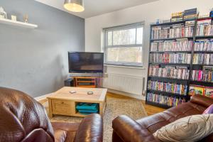 a living room with a couch and a tv and a table at Pass the Keys Well equipped apartment near A46 in Swinderby