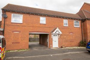 a brick building with a white door and a garage at Pass the Keys Well equipped apartment near A46 in Swinderby