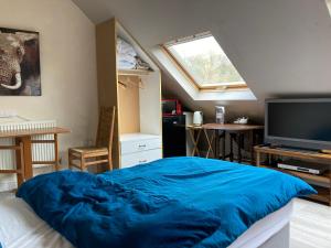 a bedroom with a large blue bed and a window at Jacks Court B2 in Stalybridge