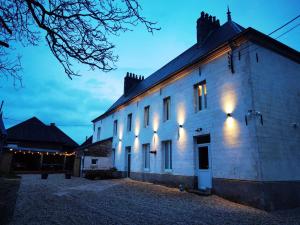 a white building with lights on the side of it at La ferme des Pommés in Pommera